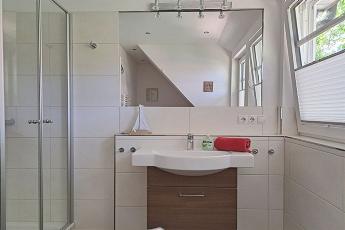 Das modern gestaltete Badezimmer im OG verfgt ber eine walk in Dusche und eine Badewanne