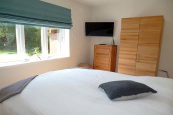 Weiterhin befindet sich im EG ein Schlafzimmer mit Doppelbett (180 x 200 cm) mit Blick zum Garten und Smart-TV.