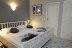 'Das groe Doppelbett (180x200) im Schlafbereich, die Tr fhrt ins Bad'